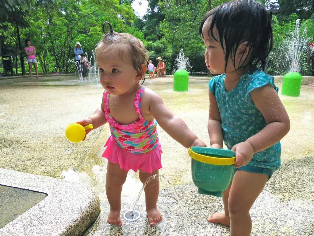 Making a new friend in the watersplash area of the Jacob Challas Children's Garden in Singapore
